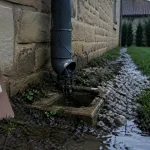 evacuation eaux pluviales : gouttière fissurée, sol humide et eau ruisselante