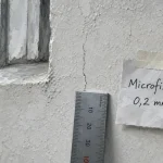 Micro fissure crépi extérieur de 0,2 mm, gros plan près d’une fenêtre