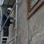 Ravalement de façade tous les combien : façade décroutée sur échafaudage, contrôle à 10 ans
